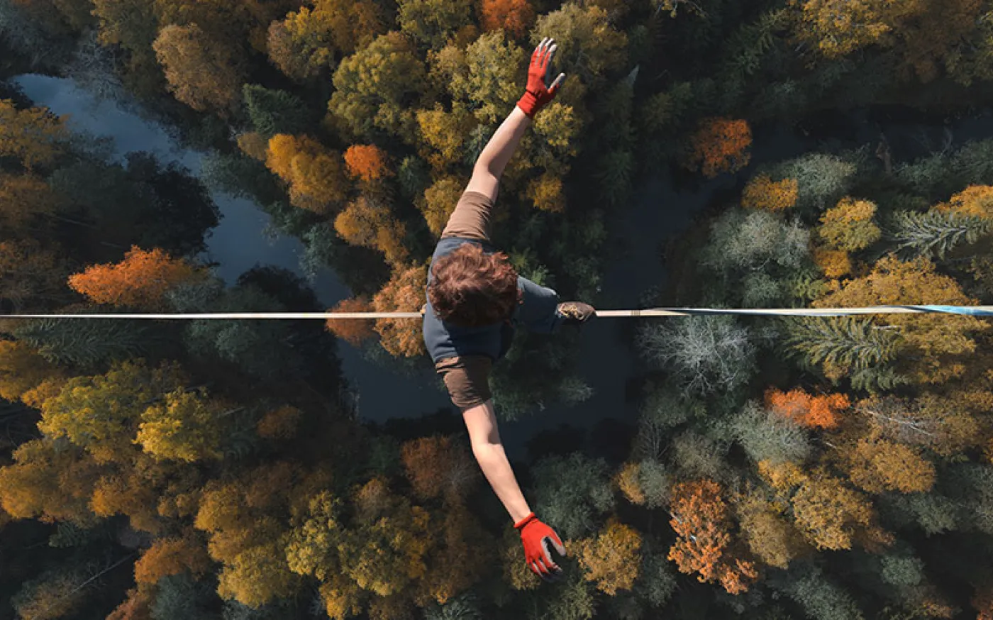 An overhead view of someone walking on a tightrope high above a forest. 